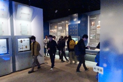 時代別の貨幣の展示を見学する学生